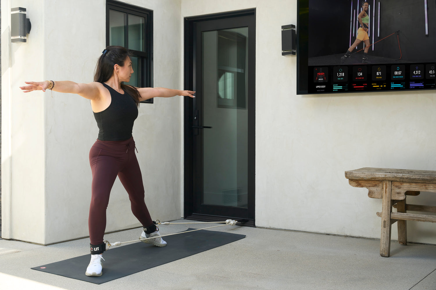 A woman doing ankle exercise with LIT Axis smart resistance band