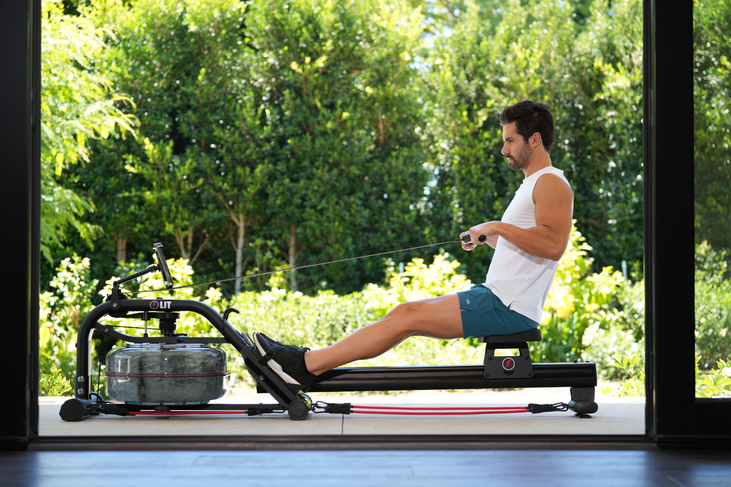 Male in white shirt using the LIT Row machine outdoors