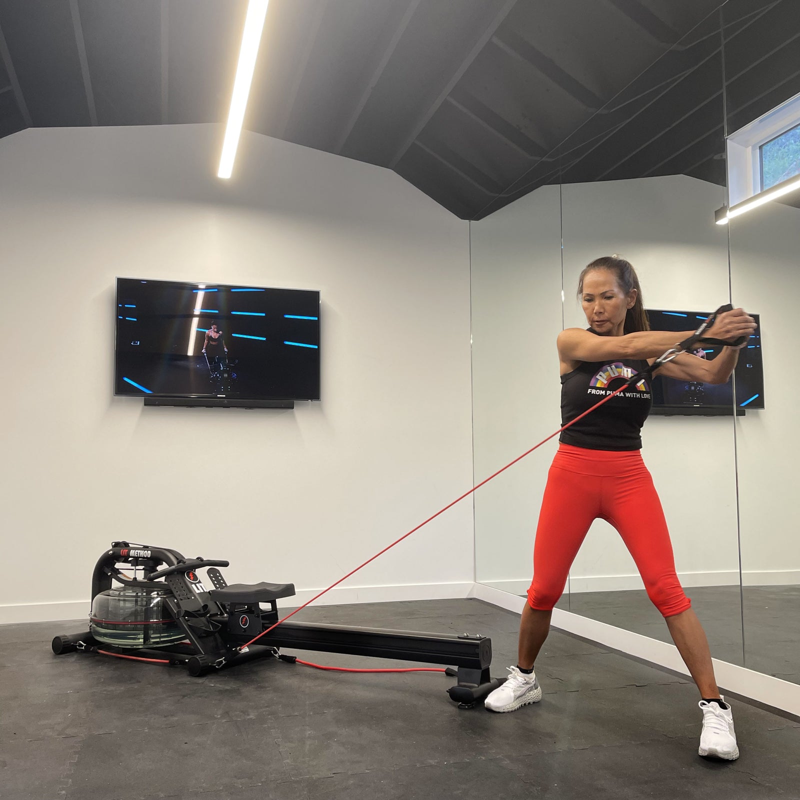 Woman in red pants using LIT bands in her basement gym