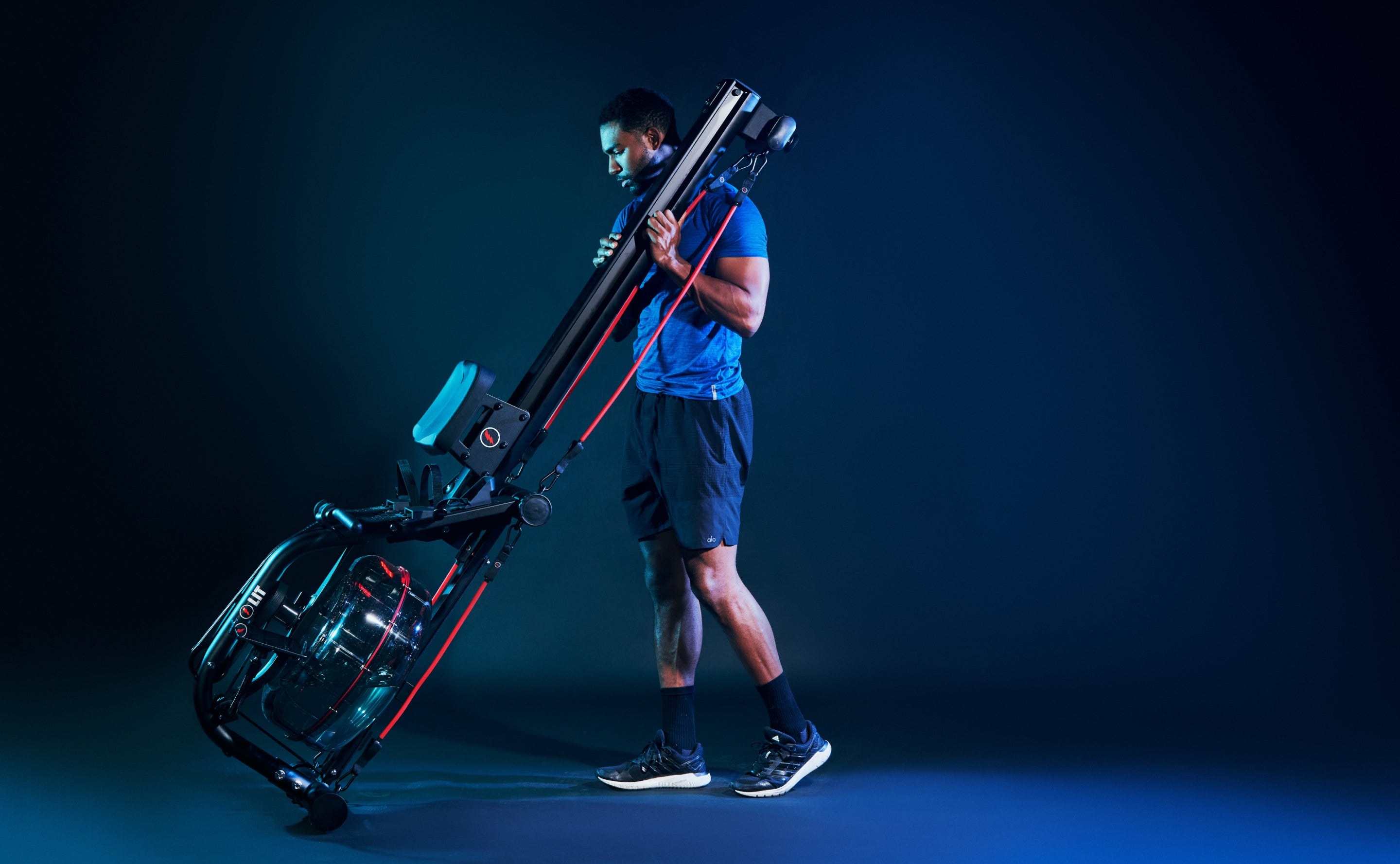 Male in blue shirt moving his LIT Strength Machine on its end