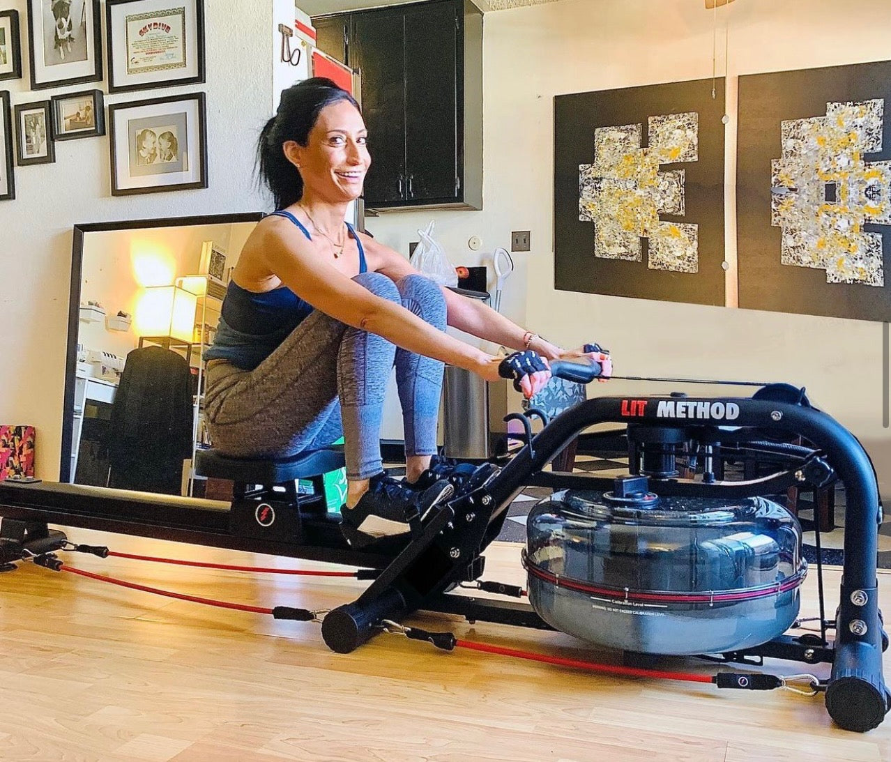 Woman in gray pants using the LIT strength machine as a rower in her office