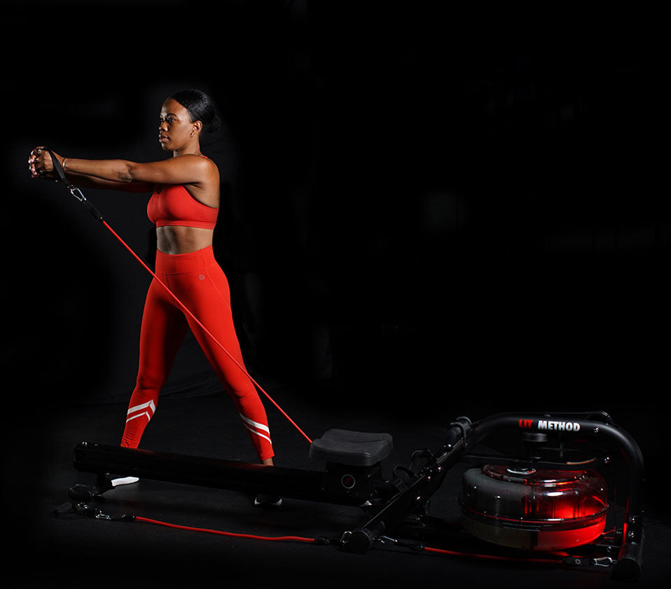 Girl in red outfit using LIT Bands to work out in a dark studio